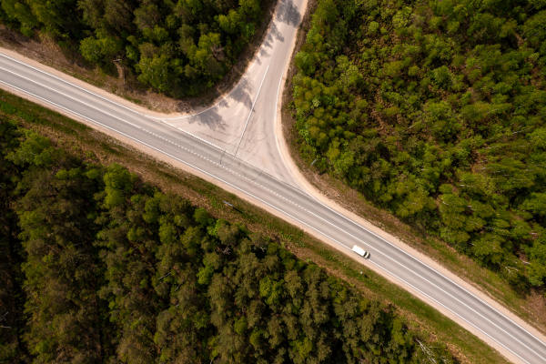top down view of road intersection in the forest at summer, drone shot