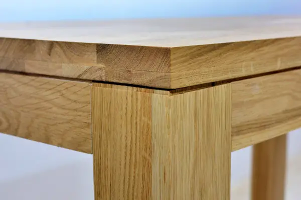 Wooden dinner table surface. Natural wood furniture close view isolated over solid background.