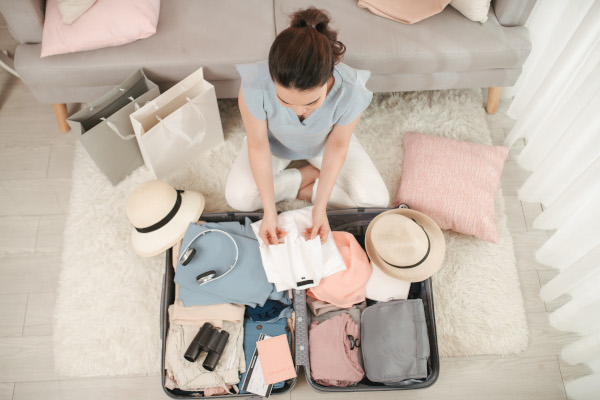 Woman hand packing a luggage for a new journey and travel for a long weekend