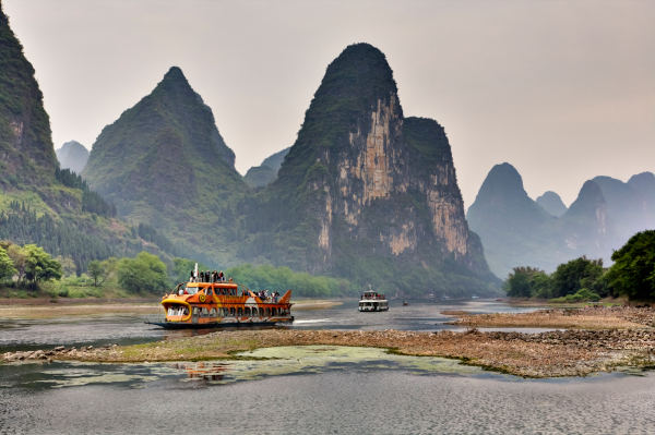 Cruise ship packed with tourists travels the magnificent scenic route along the Lijiang River from Guilin to Yangshou. southern China.
