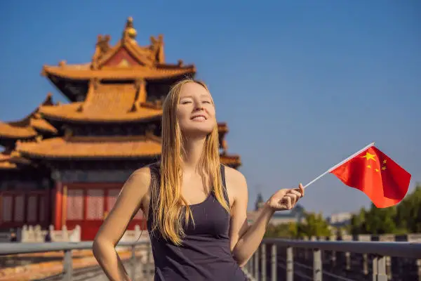 Young woman with national chinese flag in Forbidden City.