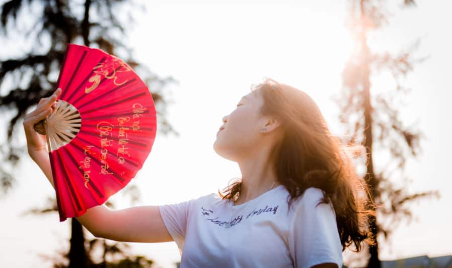 Chinese Fans - close up photo of woman holding red hand fan